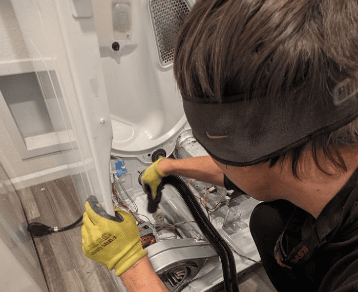 Cleaning dryer drum interior with white vinegar to remove musty mildew smell