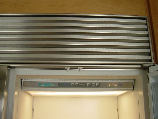 Sub-Zero refrigerator interior showing blue LCD temperature control panel and top-mount ventilation grill, Sub-Zero freezer