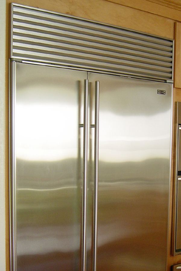 Sub-Zero 36-inch side-by-side built-in refrigerator-freezer installed with wood surround and top-mount ventilation grill