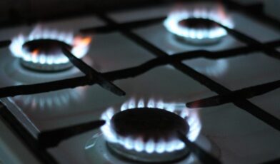 Gas range burners lit with blue flames on iron grates, the type of appliance Wilson & Myers technicians repair across Denver Metro Area