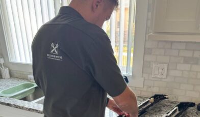 Wilson & Myers technician diagnosing a dishwasher not cleaning dishes at a Denver-Metro kitchen service call