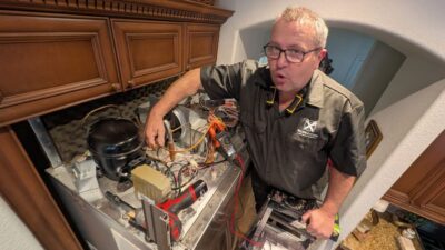 Wilson and Myers technician inspecting the interior of a refrigerator during a Denver Metro appliance repair service call