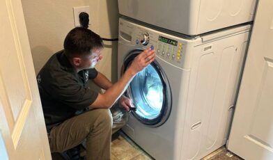 Wilson and Myers technician inspecting an LG front-load washer with door open during a Denver washer repair visit