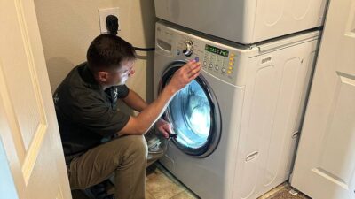 Wilson and Myers technician inspecting an LG front-load washer with door open during a Denver washer repair visit