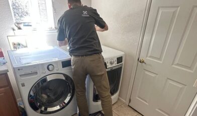 Wilson and Myers technician servicing a front load dryer in a Denver Metro laundry room