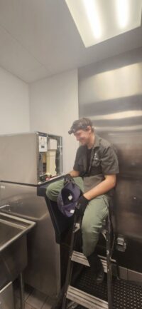 Technician reaching into a commercial ice machine head