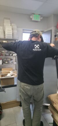 Technician cleaning an ice machine bin and dispenser area