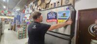 Technician servicing a cafe ice machine with gauges connected