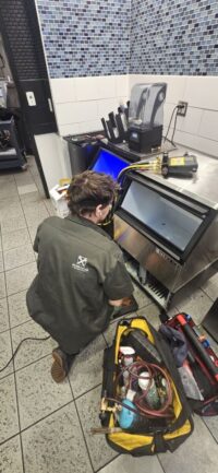 Technician diagnosing an ice machine in a Denver Metro cafe