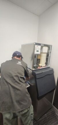 Technician servicing a floor standing ice machine