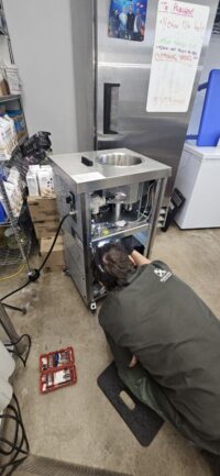 Technician checking a commercial refrigeration rack