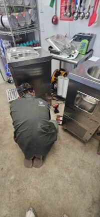 Technician checking a commercial merchandiser refrigerator