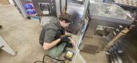 Technician servicing an undercounter commercial refrigerator