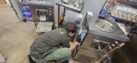 Technician checking a commercial prep table cooler