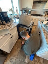 Technician inspecting the interior of a dishwasher in a Denver kitchen