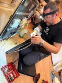 Technician checking dishwasher components with a headlamp