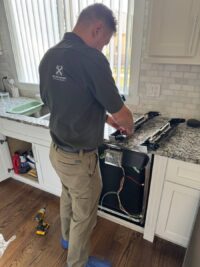 Technician reviewing dishwasher controls during a service call