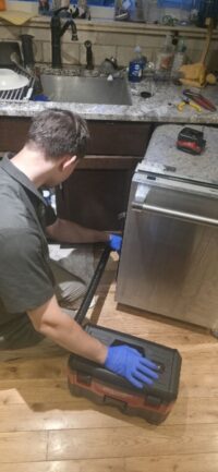 Technician checking the dishwasher water supply line