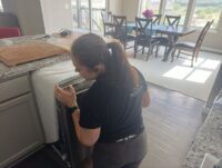 Technician checking dishwasher performance after a repair