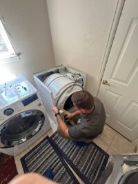 Technician servicing the internal assembly of a dryer