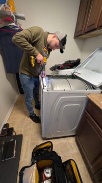 Technician opening the top panel of a dryer for control access