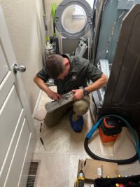 Technician clearing a blocked dryer vent line