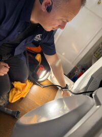 Technician holding a blower wheel removed from a dryer
