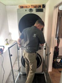 Technician servicing a dryer in a laundry closet