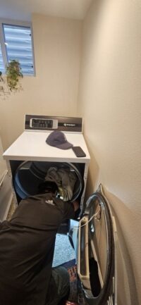 Technician checking dryer airflow in a Denver Metro home