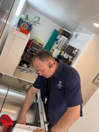 Technician inspecting a dryer drum during a service call