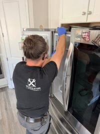 Technician in gloves inspecting a freezer interior