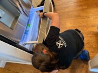 Technician working on a freezer drawer assembly