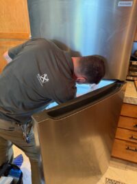 Technician leaning into a bottom freezer drawer