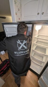 Technician servicing a freezer unit in a Denver kitchen