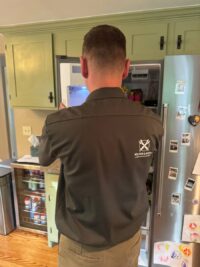 Technician checking a freezer during a Denver Metro service call