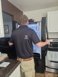 Technician working on a freezer in a Denver home