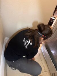 Technician servicing the lower assembly of a freezer