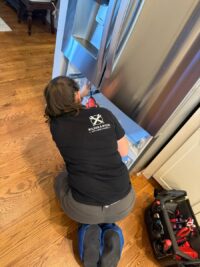 Technician with a tool case during a freezer diagnosis