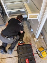 Technician laying out tools before a freezer repair