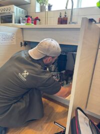 Technician checking a garbage disposal mount and wiring