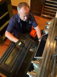 Technician checking an oven door and hinge assembly