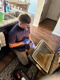 Technician inspecting an oven cavity during a heating repair