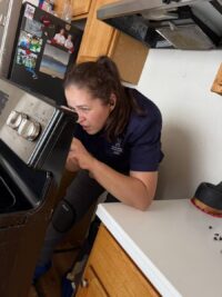 Technician diagnosing a range in a Denver kitchen