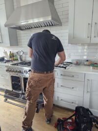 Technician checking a gas range in a Denver Metro home