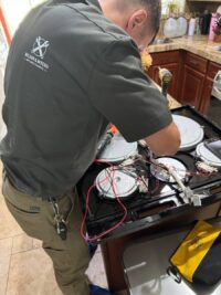 Burner caps and parts laid out during a gas range service call