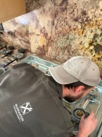 Technician servicing gas cooktop burners