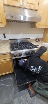 Technician working at a gas cooktop in a Denver Metro kitchen