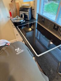 Glass cooktop lifted to reach the heating elements