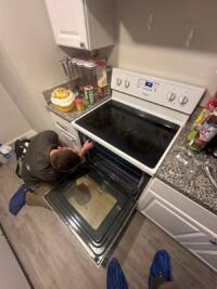 Technician servicing an electric range in Denver Metro