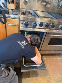 Technician reaching into the oven of a professional range